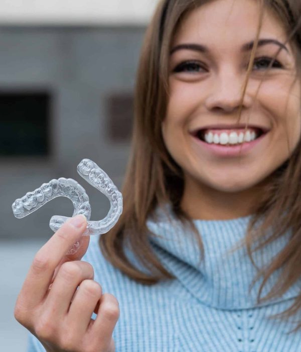 Caucasian,Woman,With,White,Smile,Holding,Transparent,Removable,Retainer.,Bite invisalign omaha