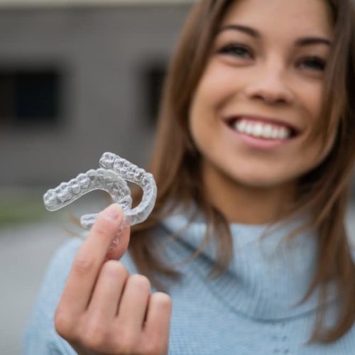 Caucasian,Woman,With,White,Smile,Holding,Transparent,Removable,Retainer.,Bite